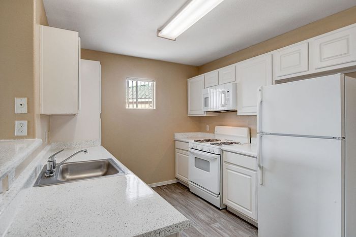 Bright and modern kitchen with sleek white cabinetry, a cozy breakfast bar, and efficient appliances.