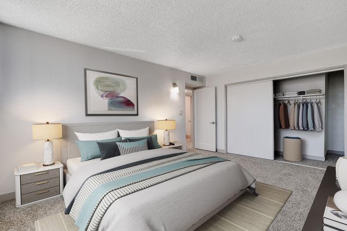 Elegant bedroom with cozy double bed, modern artwork, and a spacious closet featuring ample storage.