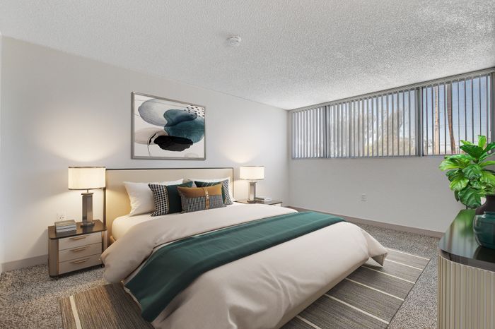 Bright and inviting bedroom with a plush double bed, stylish decor, modern art, and expansive windows letting in natural light.