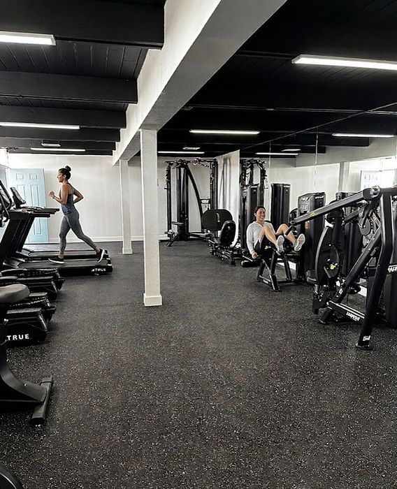 Modern fitness center with state-of-the-art gym equipment, including treadmills and strength machines in a spacious, well-lit environment.