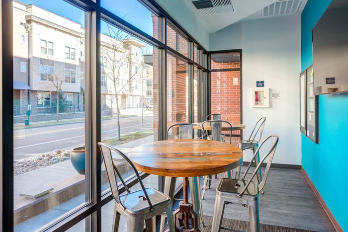 Community lounge with high-top table seating in front of floor to ceiling windows looking out to the side walk at Union on Alley.