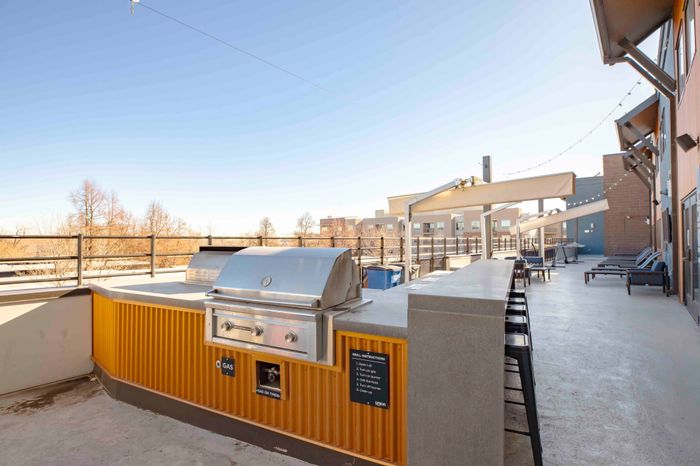 Outdoor courtyard with grills and a bar top with barstools for residents to enjoy at Union on Alley.
