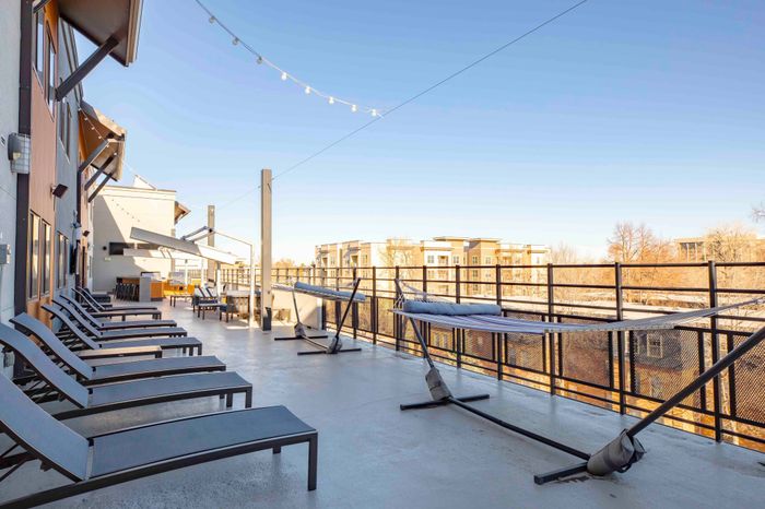 Rooftop lounge with hammocks and sun loungers overlooking the city of Fort Collins at Union on Alley.