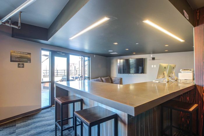 Community clubhouse at Union on Alley with high bar top seating and a door leading to the outdoor courtyard.
