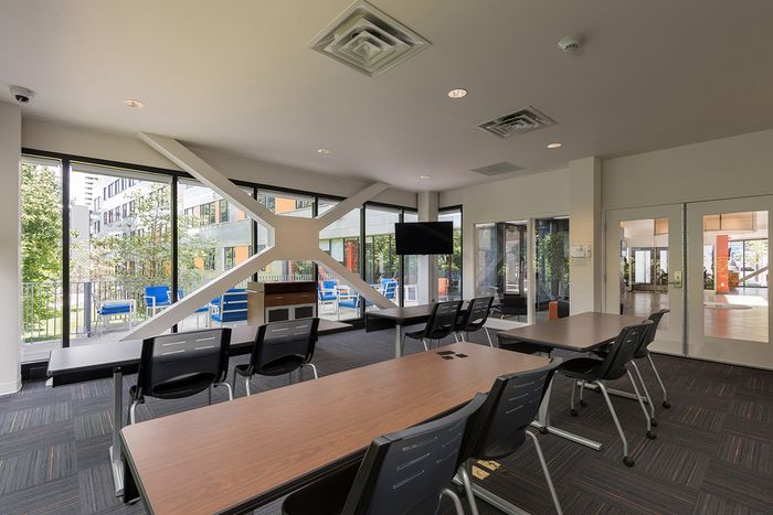 Co working space and offices at our apartments for rent in Syracuse, NY, featuring carpeted flooring and rows of desks.