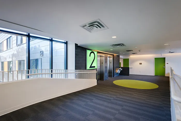 The hallway at our student housing in Syracuse, featuring tiled flooring and doors to the elevators.