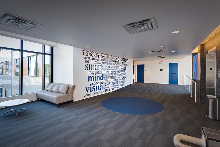 The hallway at our student housing in Syracuse, featuring tiled flooring and doors to the elevators.