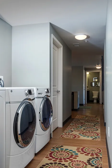 Model bathroom at our apartments for rent in Syracuse, featuring wood grain cabinetry and white countertops.