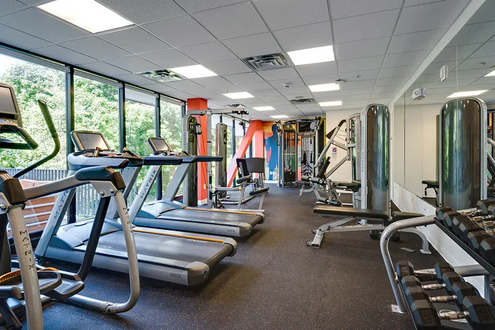 Fitness center with cardio and strength training equipment at Campus West Downtown Syracuse apartments.