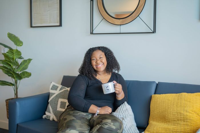 Resident smiling on couch with mug