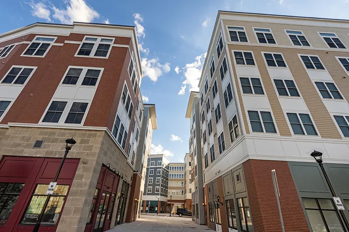 The exterior of the Oaks on the Square apartment buildings in Storrs, CT, featuring a view of the paths in between buildings.