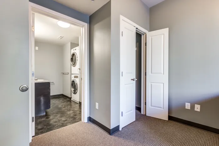 Living area view of an open-concept furnished studio at Campus West Downtown Syracuse apartments.