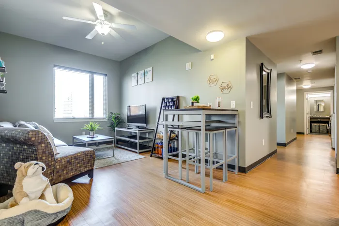 Furnished living room with a large window at Campus West, a rental option among Syracuse apartment complexes.
