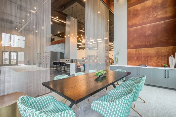 Resident lounge at our student apartments in Blacksburg, VA, featuring cushioned chairs and a well lit, spacious lobby.