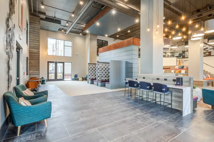 Resident lounge at our student apartments in Blacksburg, VA, featuring cushioned chairs and a well lit, spacious lobby.