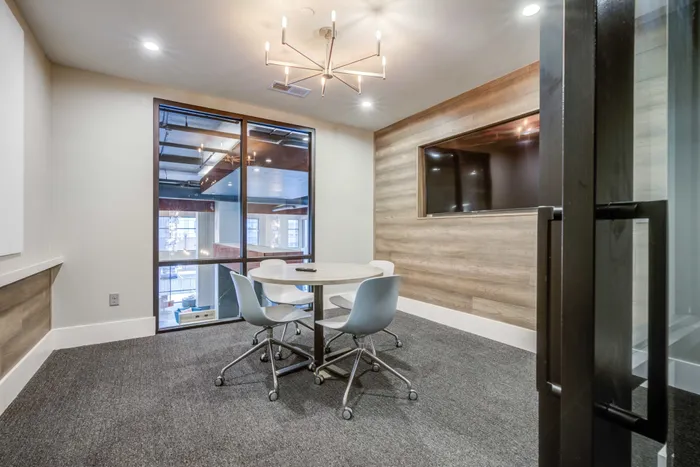 Meeting space at our apartments in Blacksburg, VA, featuring carpeted flooring and a conference table with chairs.