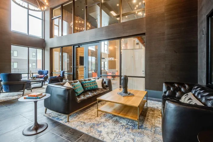 Resident lounge at our student apartments in Blacksburg, VA, featuring cushioned chairs and a well lit, spacious lobby.