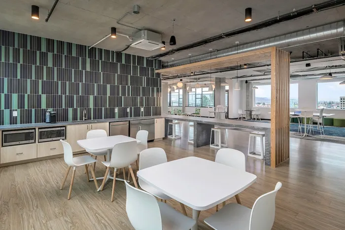 Community lounge with seating and a kitchen including microwaves, mini fridges, and sink