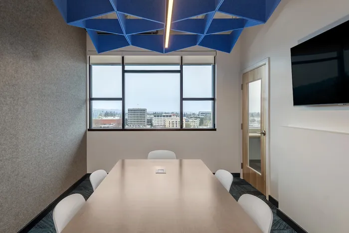 Private study room with large table, chairs, and a flat screen tv and a large window overlooking Eugene