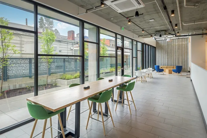 Community lounge with seating and large windows looking out at the greenery around the community