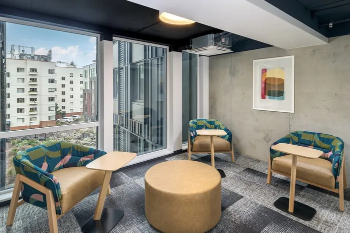 Study nook with individual tables and chairs with large windows looking out at the community