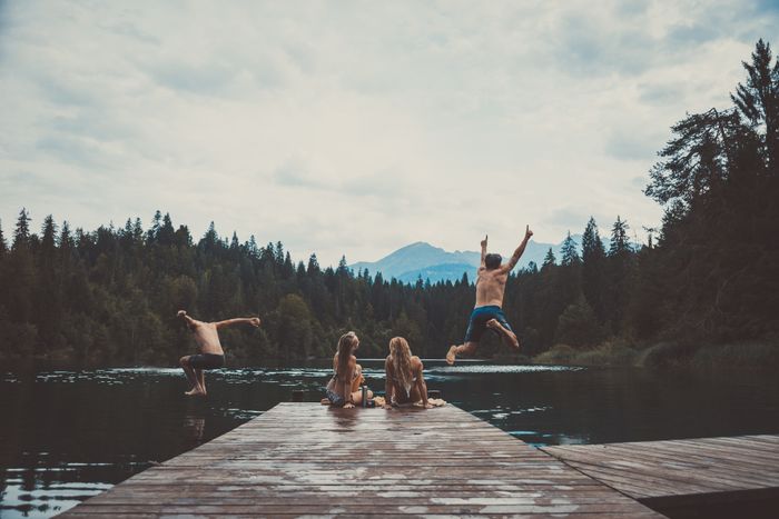 Friends hanging out around a forest lake