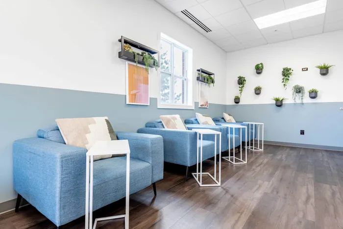 Co working space at our student apartments near Syracuse University, featuring desks, chairs, and a coffee machine.