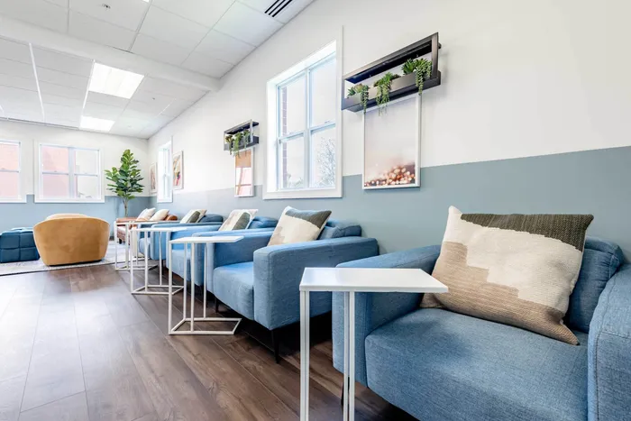 Co working space at our student apartments near Syracuse University, featuring desks, chairs, and a coffee machine.