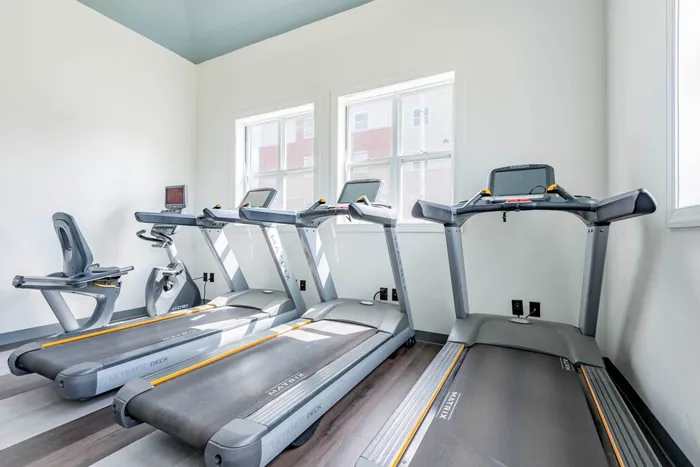 The fitness center at our apartments for rent in Syracuse, featuring treadmills and windows with a view.