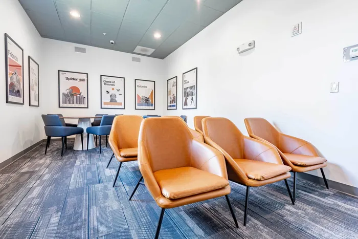 Co working space at our student apartments near Syracuse University, featuring desks, chairs, and a coffee machine.