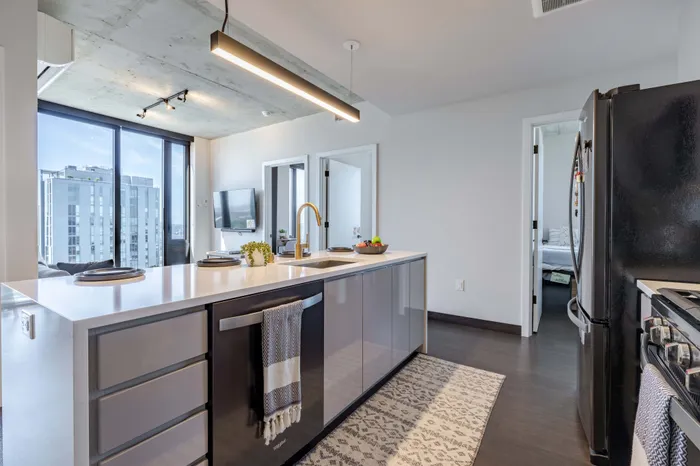 Model apartment kitchen showcasing the island facing out towards the living room