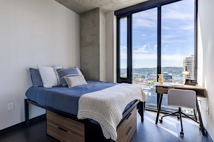 Model apartment bedroom showcasing the full size bed, desk, chair, and dressers