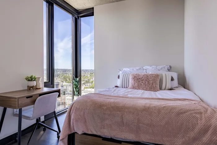 Model apartment bedroom also showcasing the full size bed, desk, chair, and dressers