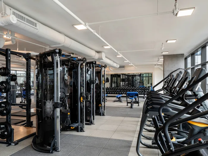 Fitness center with heavy lifting machines and cardio equipment at Union on 24th apartments in Austin near University of Texas.