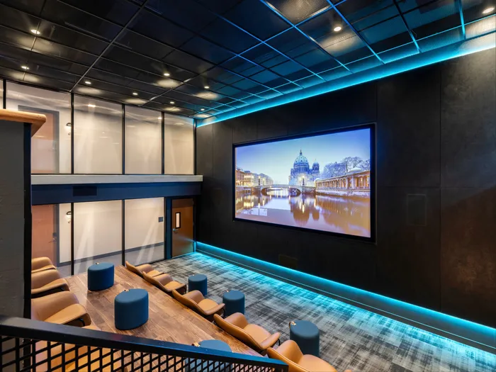 Movie theater with comfy seats all pointed at the large movie screen