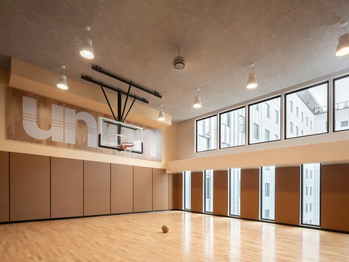 Indoor basketball court with windows looking out at the courtyard at Union on 24th apartments in Austin, TX.
