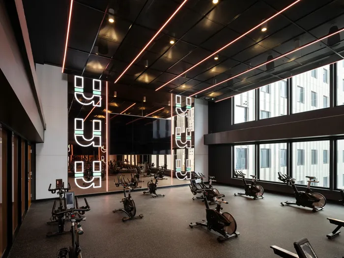 Fitness center with spin bikes all facing a large mirrored wall at Union on 24th apartments in Ausitn, TX.