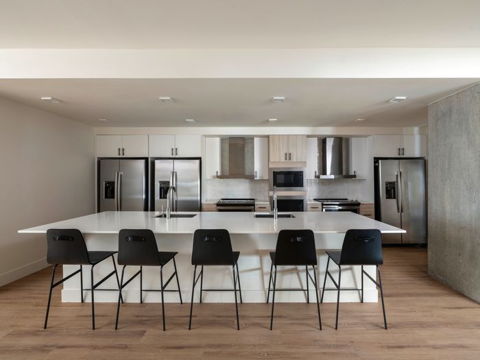 Model apartment kitchen with stainless steel appliances and a large kitchen island