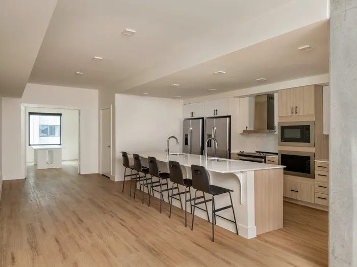Model apartment kitchen with stainless steel appliances and a large kitchen island