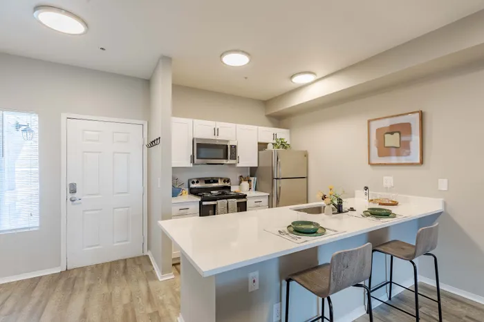 Model apartment kitchen with stainless steel appliances and white cabinets