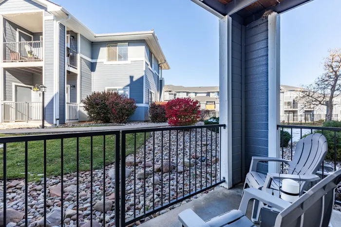 Model apartment balcony with seating looking out at the rest of the community