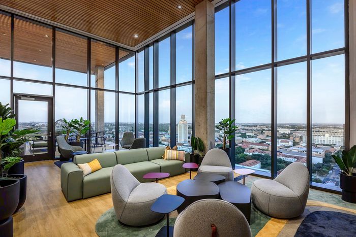 Clubhouse with comfortable seating and floor to ceiling windows looking out at the city of Austin
