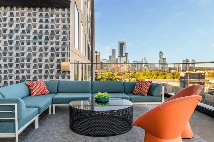 Rooftop lounge with comfortable seating at our apartments for rent in Austin, TX, featuring outdoor furniture and a view of the city.