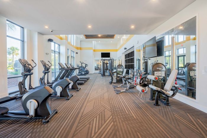Fitness center with cardio equipment like treadmills, ellipticals, and stair climbers, as well as other heavy lifting equipment