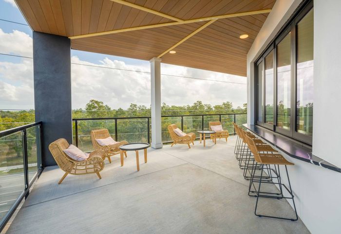 Outdoor patio lounge with seating that looks out a the greenery around the community