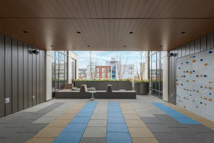 Outdoor Fitness lounge with mats and a rock climbing wall.