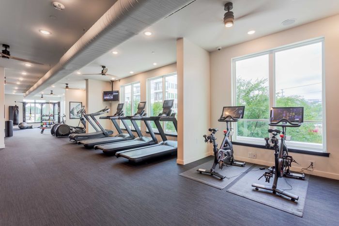Modern fitness center with treadmills, exercise bikes, and panoramic windows offering scenic views for an energizing workout experience.