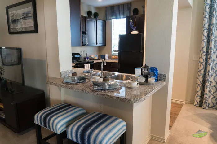 Modern kitchen nook with elegant granite countertop, stylish bar stools, and a cozy dining setup, offering a perfect blend of functionality and comfort.