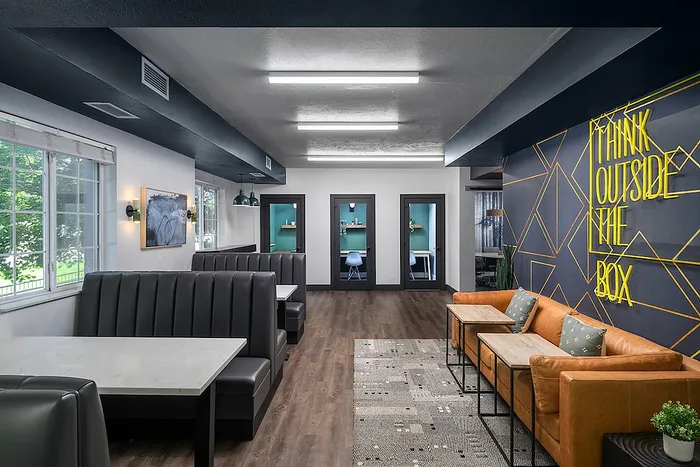 Study and co-working space with booths and wall art at Campus Village apartments near Michigan State University.