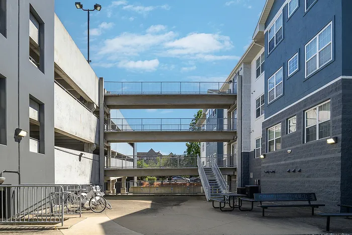 Modern urban apartment complex with spacious outdoor walkways and a vibrant community atmosphere.